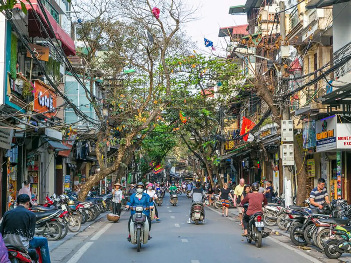 Narrow street in Hanoi Old Quarter with motorbikes and shopfronts