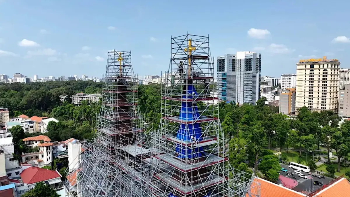 The gilded cross being carefully hoisted to the 60.5m spire of Notre-Dame Cathedral
